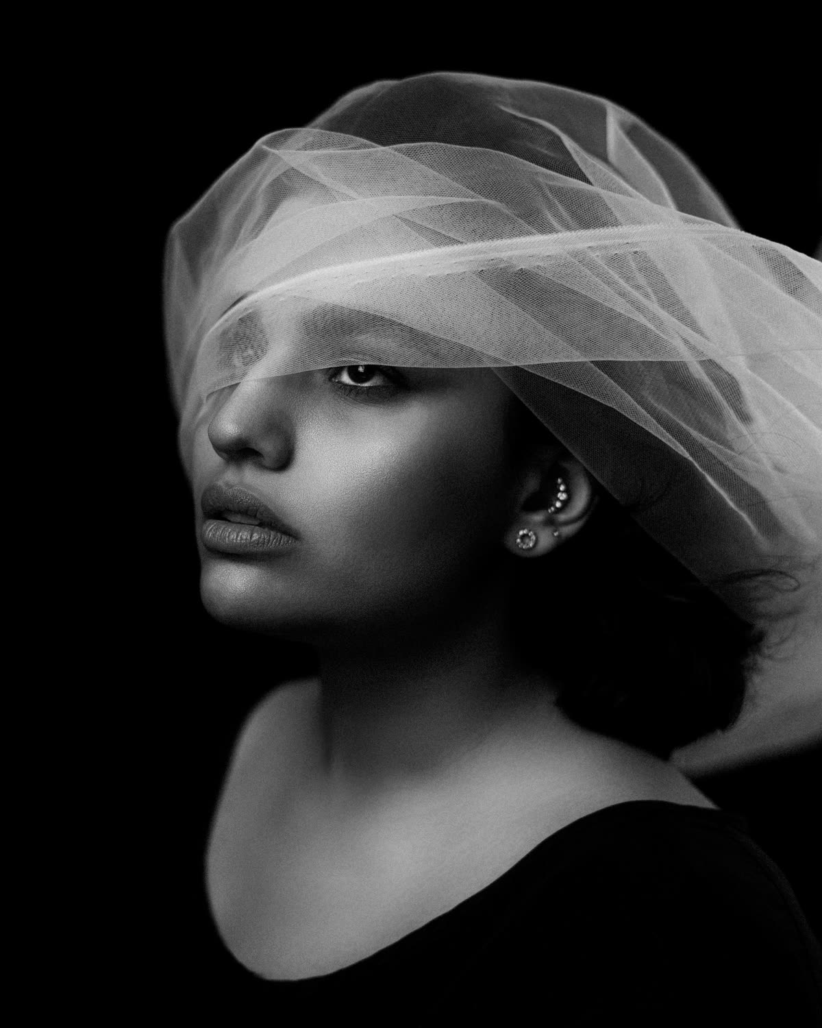 Portrait en noir et blanc derrière un voile translucide