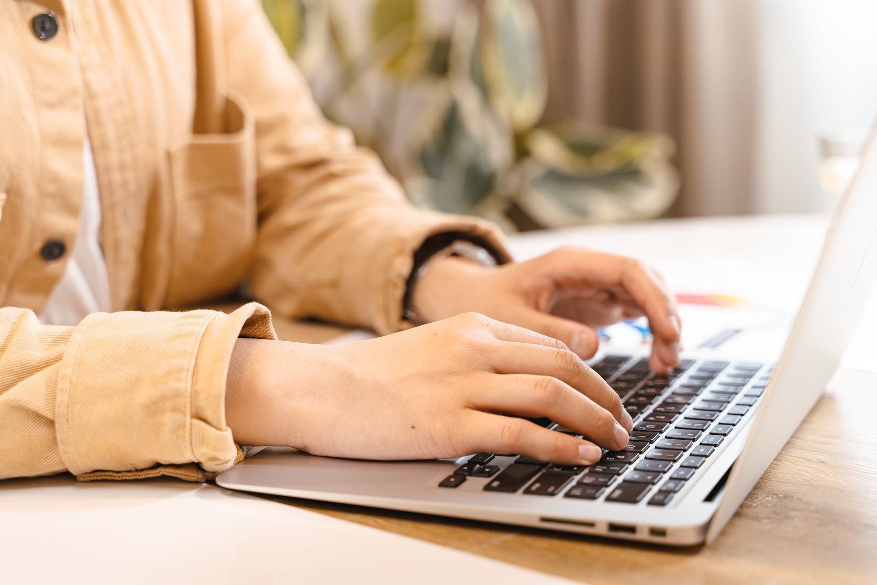 Mains sur le clavier d’un ordinateur portable, à la lumière du jour